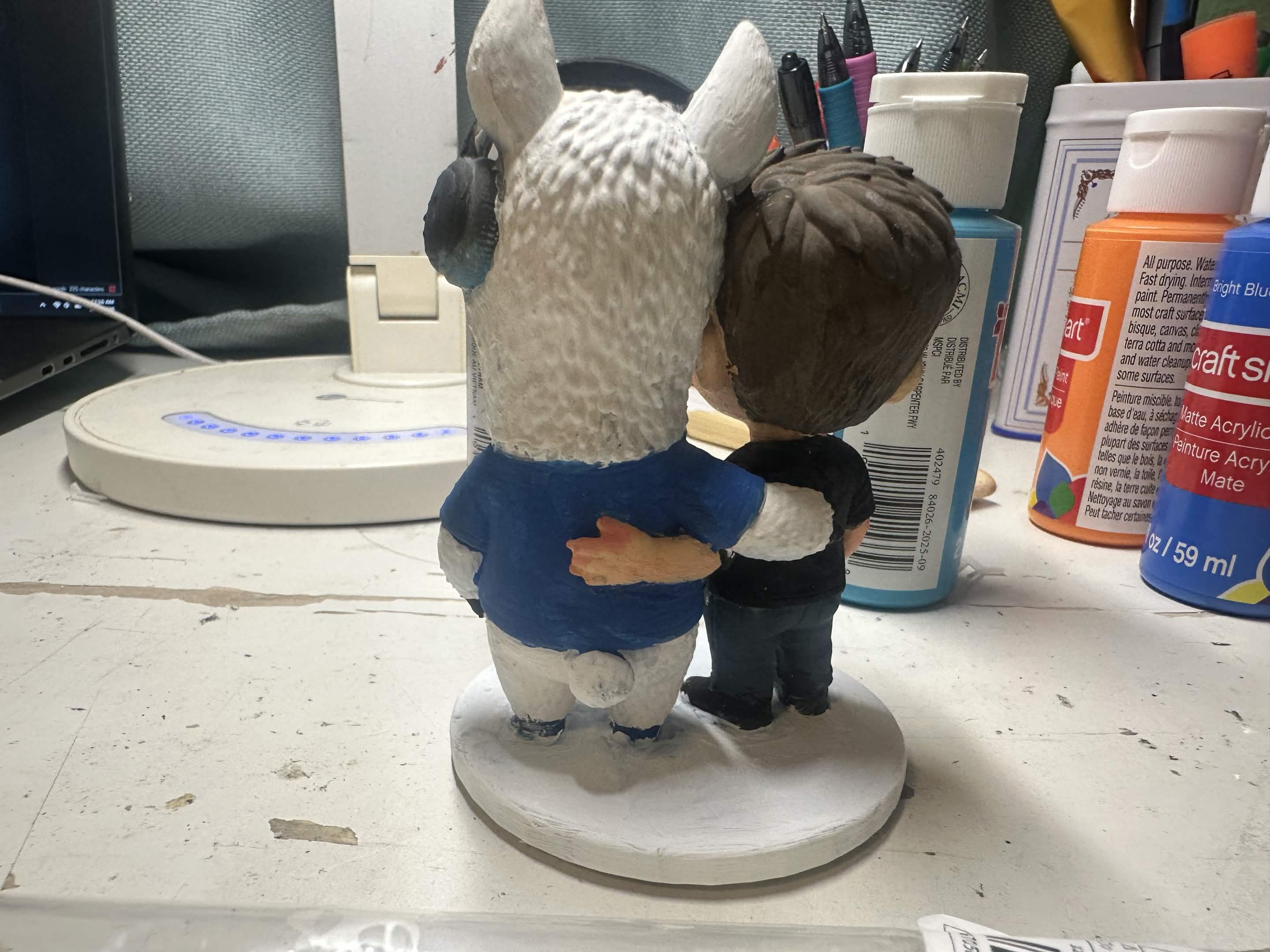 Back view of the figurine, the two with an arm around each other