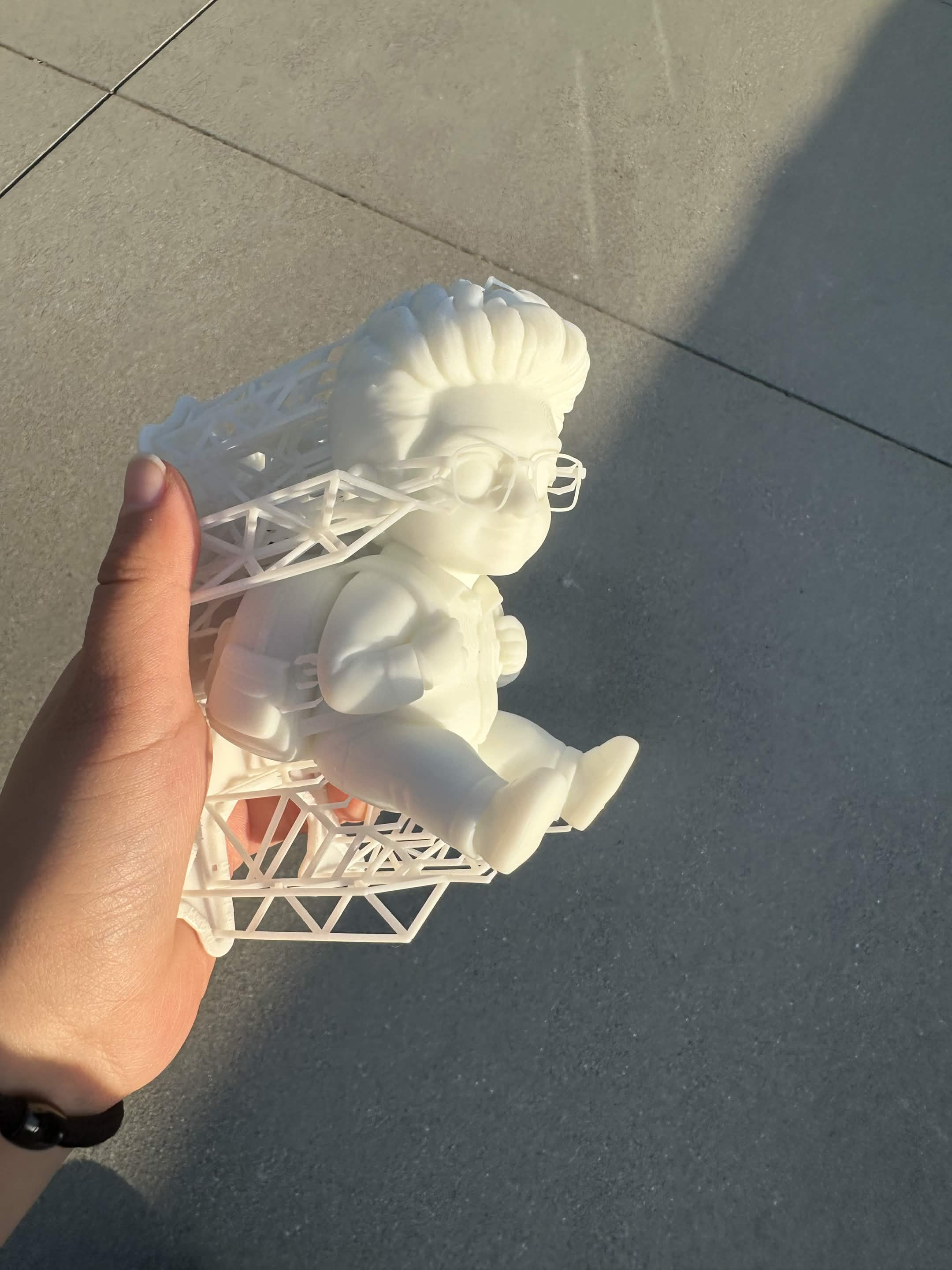 Freshly printed white resin figurine still attached to its support structure