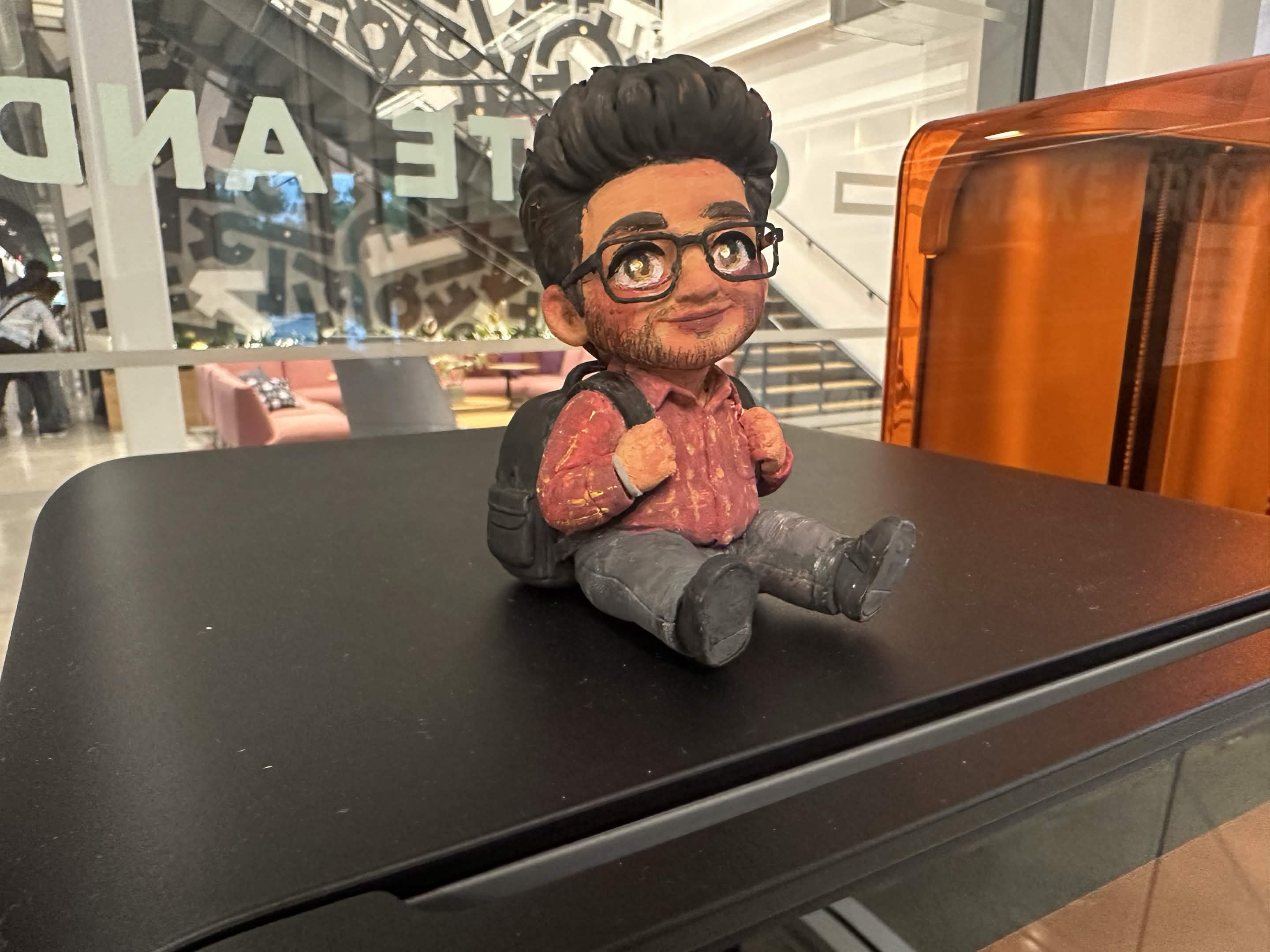 The finished painted figurine sitting on top of the 3D printer