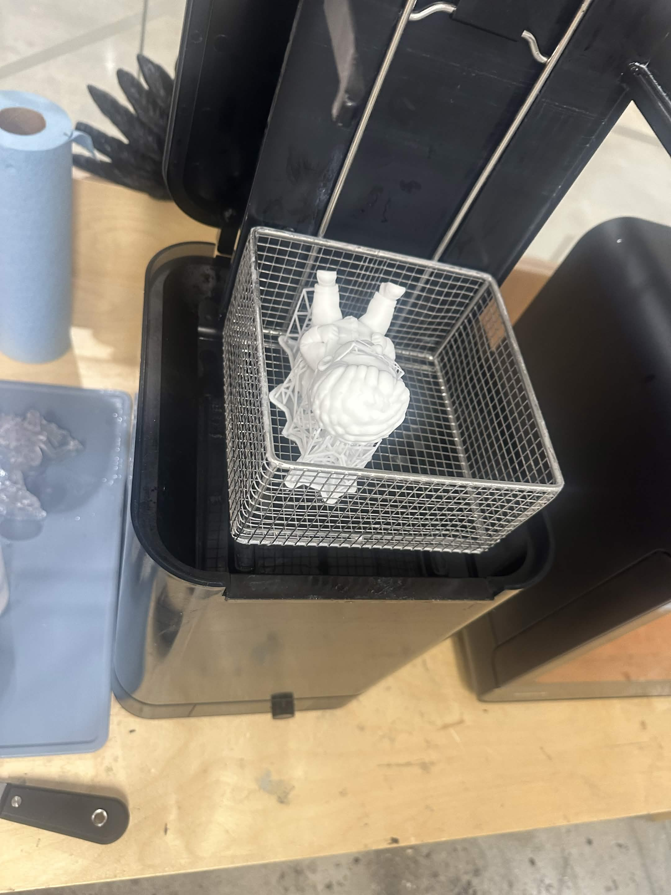 The print sitting in a wire basket in the wash station